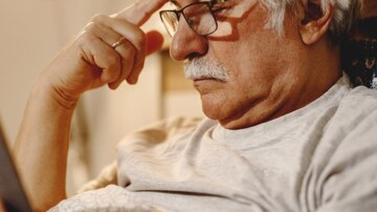 homme-senior-pensif-lisant-livre-tout-se-relaxant-dans-chambre_637285-10427