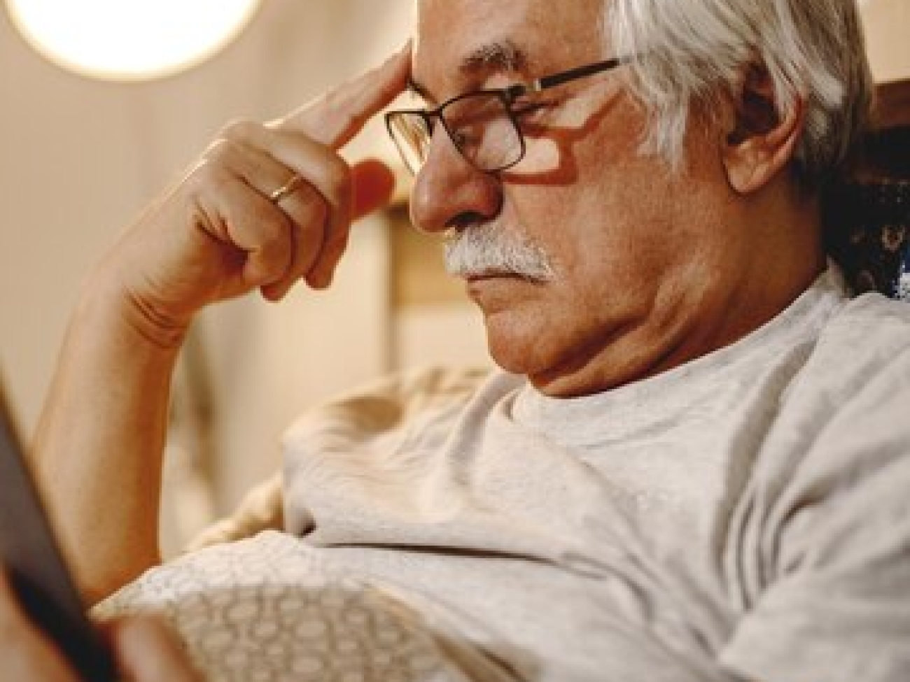 homme-senior-pensif-lisant-livre-tout-se-relaxant-dans-chambre_637285-10427