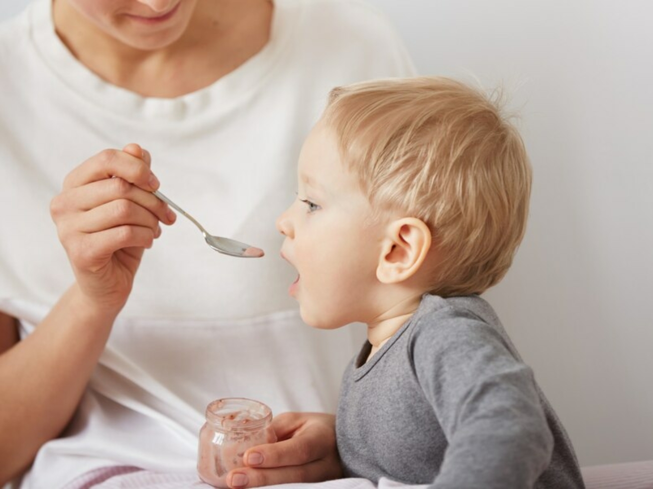 mere-nourrir-son-petit-garcon-cuillere_273609-14847