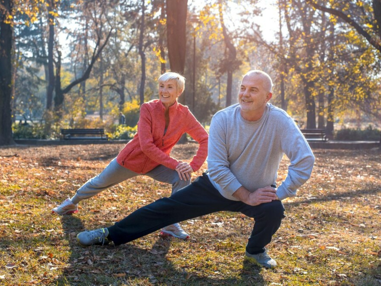 gros-plan-couple-personnes-agees-caucasien-souriant-faisant-exercice-dans-parc-par-journee-ensoleillee-automne_181624-58025