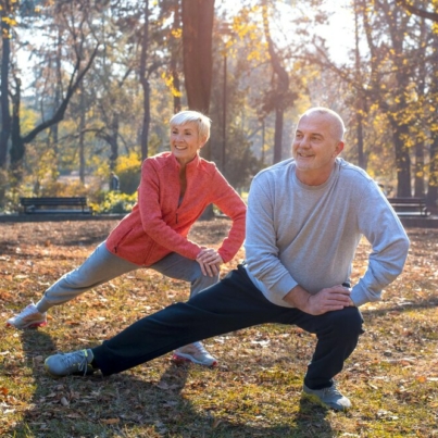 gros-plan-couple-personnes-agees-caucasien-souriant-faisant-exercice-dans-parc-par-journee-ensoleillee-automne_181624-58025