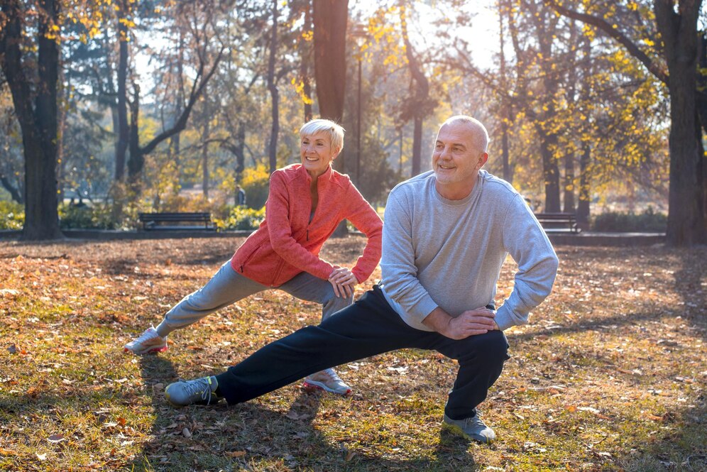 gros-plan-couple-personnes-agees-caucasien-souriant-faisant-exercice-dans-parc-par-journee-ensoleillee-automne_181624-58025